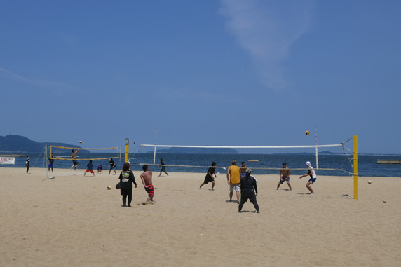 砂浜でビーチバレーを楽しむ若者